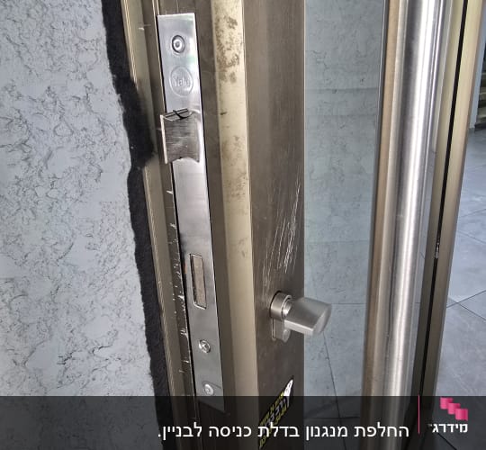 דלת מתכת עם מנעול וידית כסופה